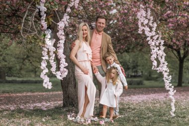 Spring. Happy couple in sakura park. Happy family in spring gard