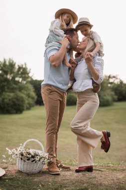 Children, dad and mom play in meadow in sunshine. mother, father