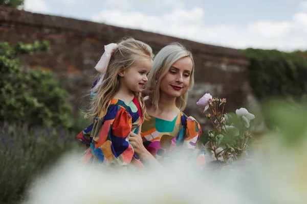 ローズの花の庭で娘を持つ母 — ストック写真
