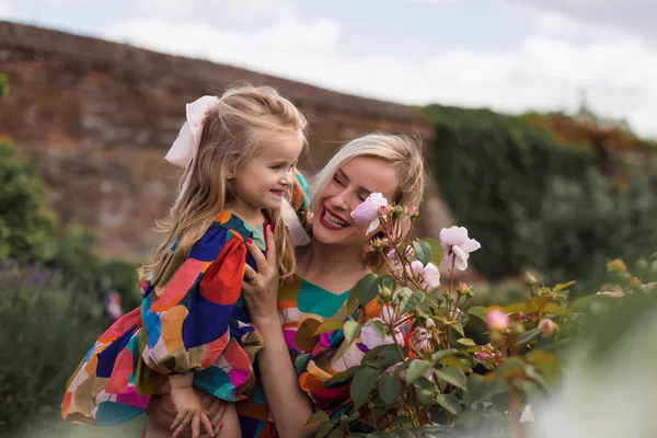 ローズの花の庭で娘を持つ母 — ストック写真