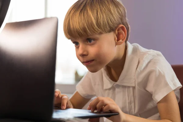 快乐的男孩坐在他的办公桌前 带着笔记本电脑 高质量的照片 — 图库照片