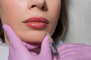 Dudaklarına botoks yaptıran bir kadının portresi yakın plan. Güzel bir kadın yüzüne botoks yaptırıyor. Yetişkin bir kız klinikte botoks yaptırıyor. Güzellik tedavileri