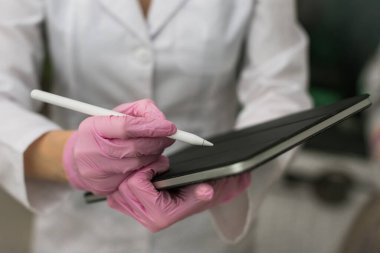 Kadın doktor hastanede dikilirken tablet bilgisayar kullanıyor. Yüksek kalite fotoğraf