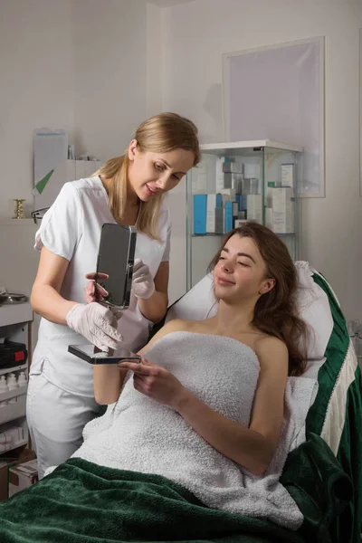 Tevreden Jonge Vrouw Kijken Spiegel Ontroerende Gezicht Professionele Cosmetologie Behandeling — Stockfoto