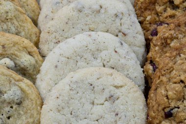 Ev yapımı çeşitli kurabiyeler dikey olarak sıralanmış ve sergilenmiş. Şeker ve yulaf ezmesi aromaları gösteriliyor, seçici bir odak ile yakın plan.