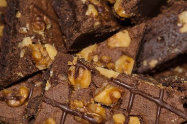 Üstü cevizli çikolatalı brovniler servis tabağında. Ev yapımı pişirilmiş mallar, seçici odaklı soyut yakın çekim..