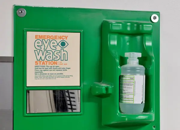 Emergency eye wash station safety kit with directions attached to a wall. Laboratory and industrial safety concept.