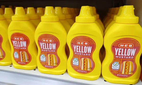 Houston, Teksas ABD 08-25-2024: Sarı hardal şişeleri Plastik süpermarket raf HEB marka.
