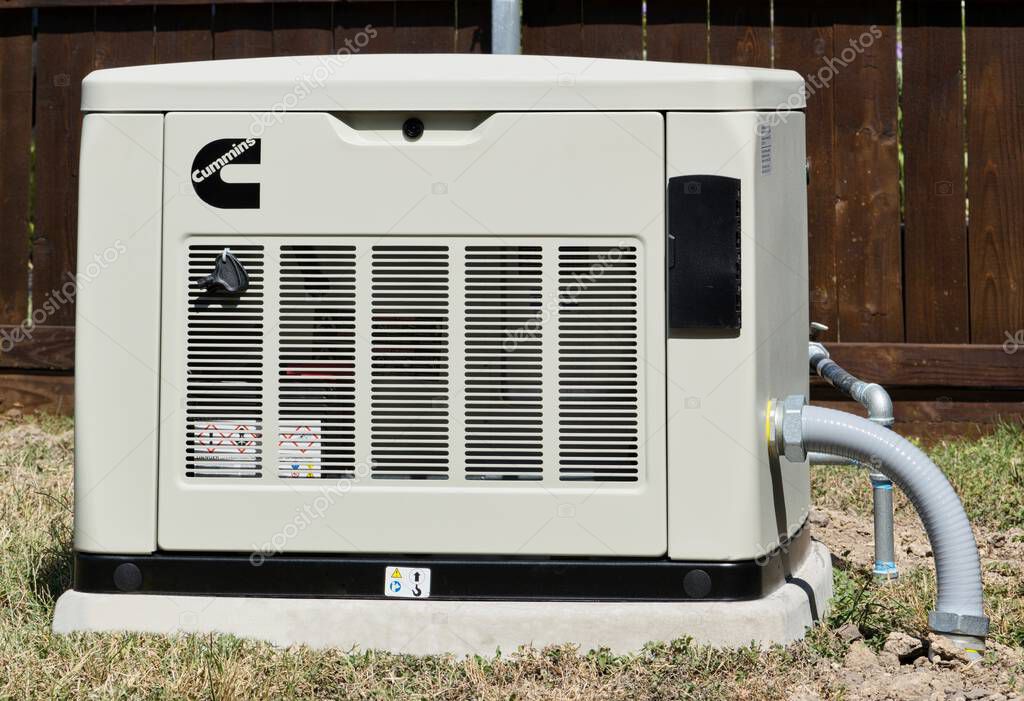 Houston, Texas USA 10-11-2024: Cummins standby generator in residential backyard power outage backup supply.