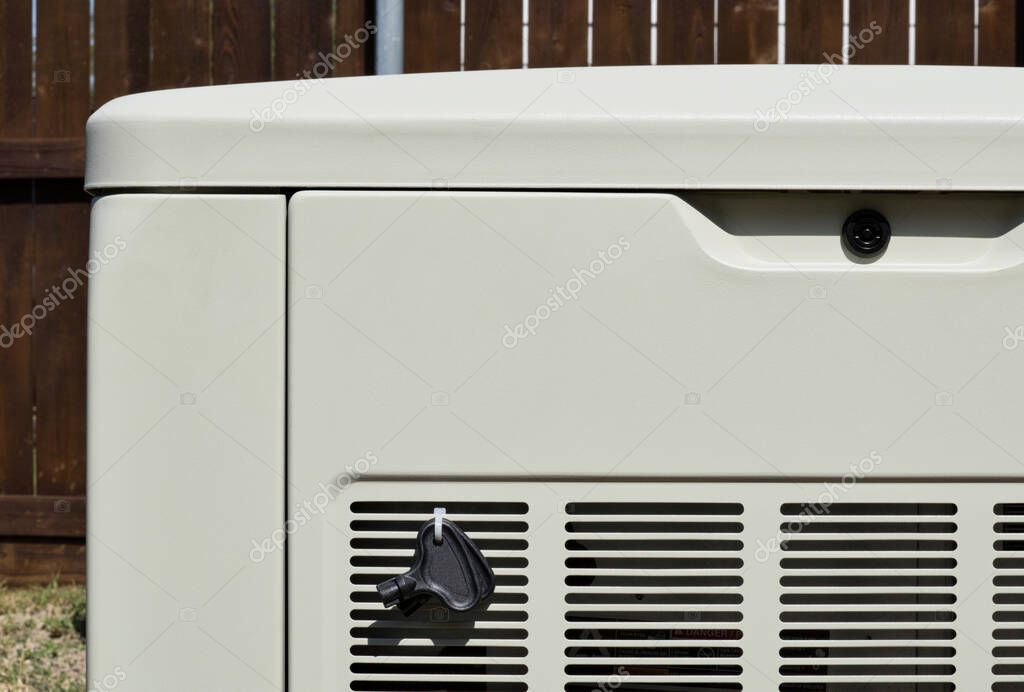 Standby home generator set partial in residential backyard, emergency backup power supply electricity generation.