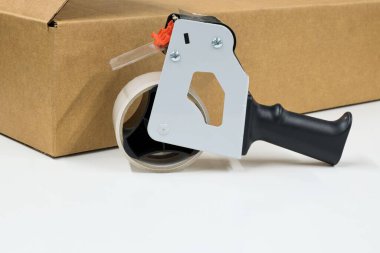 Teyp tabancası dağıtıcı karton kutu paket gönderme kavramını kopyalama alanı ile mühürlüyor.