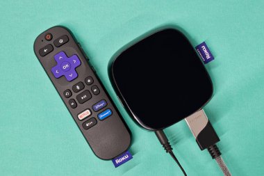 Houston, Teksas ABD 05-01-2024: Roku yayın yapan medya oyuncusu uzaktan kumandalı mavi arkaplan.