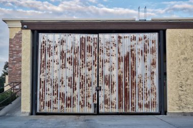 Çöp konteynırı üzerindeki paslı kapılar kapalı ticari bina dış.