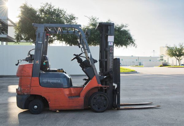 Houston, Texas USA 07-13-2025: Toyota forklift parked outside warehouse business side view.