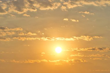 Morning haze sunrise partly cloudy sky replacement background orange glow with plane flying in distance.