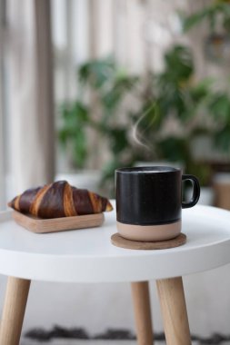 Beyaz masada buğulanmış kahve ve kruvasan. Fransız kahvaltısı. Metnin için boşluk kopyala