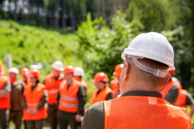 Mühendis ekibi iş için hazır. Çelik yelek giyen işçi grubu, güvenlik. Bina konsepti. Mimarcı, inşaat alanında mühendisler. İnşaatçı adam. Miğfer yapımcısı. Birçok inşaat işçisi miğferi.