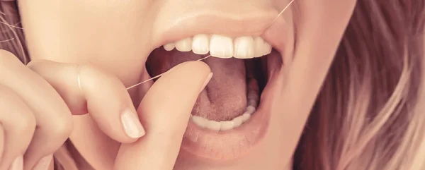Smiling women use dental floss white healthy teeth. Dental flush - woman flossing teeth.