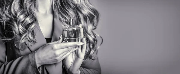 Woman presents perfumes fragrance. Womans with perfum bottle. Beautiful girl using perfume. Woman with bottle of perfume. Black and white.
