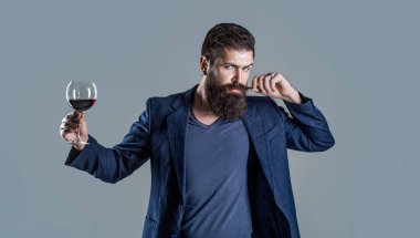 Man with a glass of red wine in his hands. Sommelier, degustator with glass of wine, winery, male winemaker. Beard man, bearded, sommelier tasting red wine.