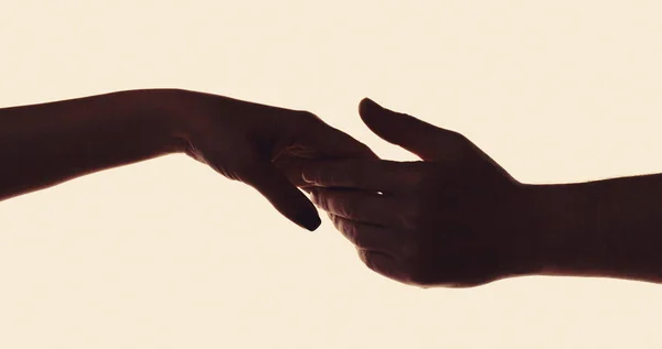 Mercy, two hands silhouette, connection or help concept. Concept human relation, community, togetherness symbolism