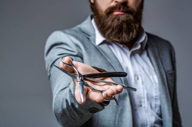 Berber dükkanını ziyaret eden sakallı bir müşteri. Berber makası, jilet, berber, takım elbise. Klasik berber dükkanı, tıraş. Portre sakallı adam. Bıyıklı adamlar. Acımasız adam, makas, düz jilet..