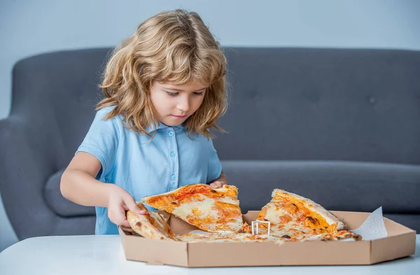 Little boy eating pizza. Cute little boy eats pizzas. Happy handsome young teen boys holding slice pizza. Little boy holding pizzas boxes. Boy ready to eat pizza. Little child looking at a pizzas box.