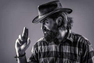 Batı, silahlar. Kovboy portresi. Şapkalı kovboy portresi. Kovboy şapkalı, silahlı bir adamın portresi. Kovboy portresi. Siyah ve beyaz.