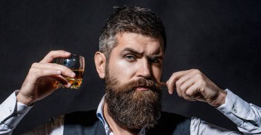 Viski, konyak, konyak içen bir adam. Degukasyon, tatma. Tatma ve degukasyon konsepti. Zarif takım elbiseli sakallı bir işadamı ve bir bardak viski..