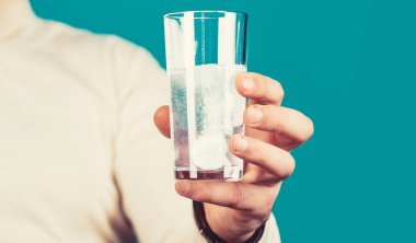 Elinde hap tutan adama yaklaş. Bir bardak su tableti. Köpüklü suda köpüren tabletle dolu cam..