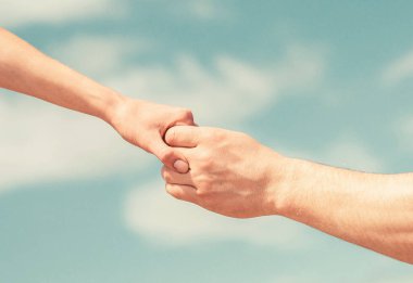 Dayanışma, şefkat ve yardım, kurtarma. Yardım eli uzatıyorum. Mavi gökyüzündeki kadın ve erkeğin elleri.