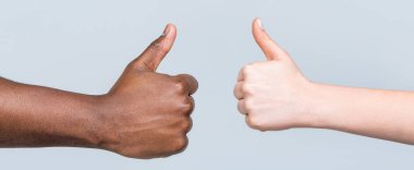 Kadın elleri baş parmağını kaldırıyor. Siyahların hayatı önemlidir. Destek desteği. Afrika erkek eli baş parmağını gösteriyor. Siyah ve beyaz eller birlikte görünüyor..