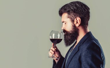 Elinde bir kadeh kırmızı şarap. Sommelier, bir bardak şarap, şarap imalatçısı, erkek şarap üreticisi. Sakallı adam, sakallı, şarap içen şarap garsonu..