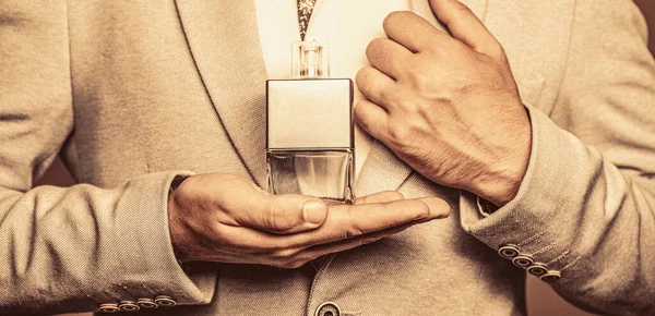 Male holding up bottle of perfume. Perfume or cologne bottle and perfumery, cosmetics, scent cologne bottle, male holding cologne.