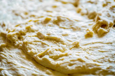 Makro seçici odaklı ham hamur dokusu arkaplanı. Yuvarlanmış hamur dokusu. Hamur işlerinin arka planı. Pizza ya da ekmek pişirmek için taze çiğ hamur. Yakın çekim mayalanmış hamur, ev yapımı..