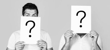 İsimsiz bir adam, sorgulama sembolünün arkasına bakıyor. Erkek bilinmezliği. Bir sorum var, anonim, habersiz. Soru işaretli kağıt notlar. Siyah ve beyaz.