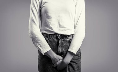 Elleri kasıklarını tutan bir kadına yaklaş. Kadın Elleri Kasığından Tutuyor. Hasta kadın elleri kasığının altını bastırıyor. Tıbbi ya da jinekolojik sorunlar. Siyah ve beyaz.