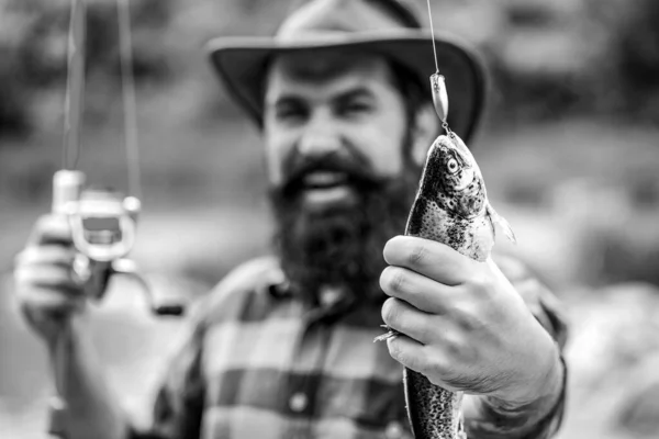 漁師とマス 釣りの背景 男は大きな魚のマスを手に持っている 漁師とトロフィーのマス マスの魚を持っている男 黒と白 — ストック写真