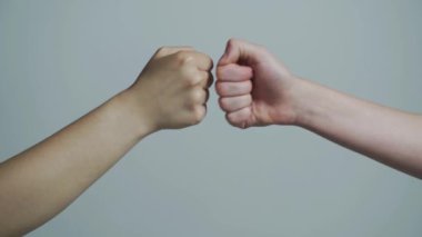 Adam yumruk tokuşturuyor. Takım konsepti. Erkeklerin elleri yumruk tokuşturma takım çalışması, başarı. İnsanlar yumruklarını birbirine vuruyor, kollarını. Dostça el sıkışalım, dostça selamlaşalım.