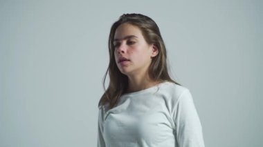 Diş ağrısı, diş çürüğü ya da hassasiyet çeken bir kız. Diş ağrısı, diş enfeksiyonu olan kadın. Gri arka planda diş ağrısı çeken bir kadın. Diş ağrısı çeken genç bir kadın..