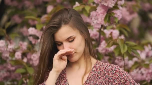 Чихающая Молодая Девушка Дворником Носа Среди Цветущих Деревьев Парке Аллергия — стоковое видео