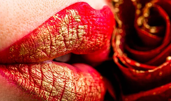 官能的な唇 バラの花を持つ女性 赤い口紅でセクシーな女性の唇を閉じます 赤いバラの女性の唇のクローズアップ 赤い色の口紅でセクシーな女性の唇を閉じます 女性の唇と赤い花 — ストック写真
