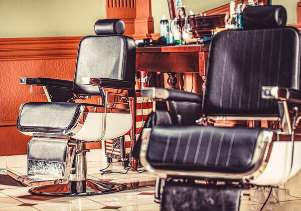 Professional hairstylist in barbershop interior. Modern hairdresser and hair salon, barber shop for men. Stylish vintage barber chair.