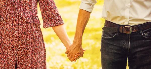 情侣牵手 年轻夫妇牵着手在公园里散步 等一下 情侣手牵手在公园里 — 图库照片