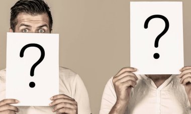 Erkek bilinmezliği. Bir sorum var, anonim, habersiz. Soru işaretli kağıt notlar. Soru işareti olan adam. İsimsiz bir adam, sorgulama sembolünün arkasına bakıyor..