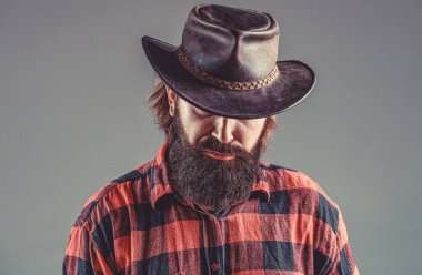 Tıraşsız kovboylar. Amerikan kovboyu. Deri Kovboy Şapkası. Kovboy şapkası takan genç bir adamın portresi. Şapkalı kovboylar..