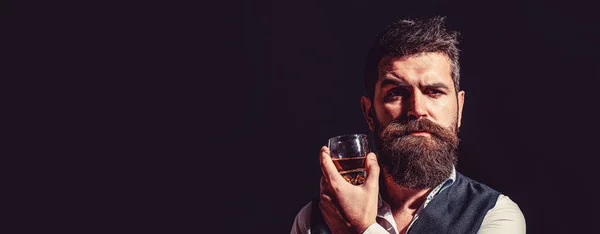 ウイスキーを飲んでる 太い髭を生やした男の肖像 マシン ドリンク 髭の男はガラスのブランデーを持っている 髭を生やしたドリンクコニャック ウィスキーを持ってる男 — ストック写真