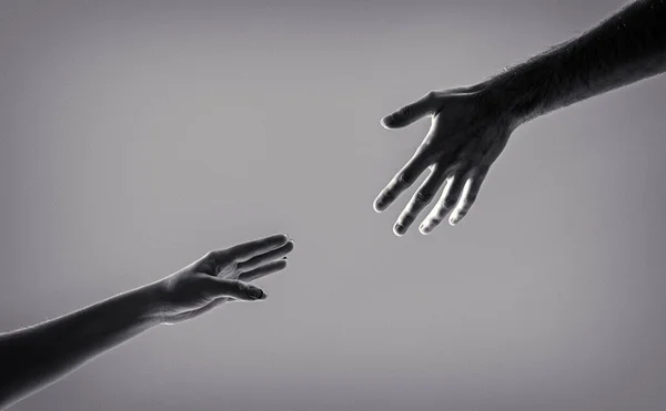 Helping hand outstretched, isolated arm, salvation. Two hands, helping arm of a friend, teamwork. Black and white.