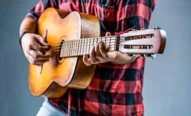 Gitar çalan erkek müzisyen, müzik aleti. Akustik gitar çalan erkek elleri, yakın çekim. Akustik gitarlar çalıyor. Sahnede gitarist. Gitar çalarak elinizi kapatın. Gitar akustiği.