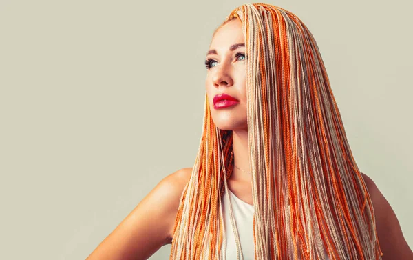 Beautiful stylish woman with colorful kanekalon braided in her hair. Pretty woman colorful orange hair braids. Hairdresser salon concept.